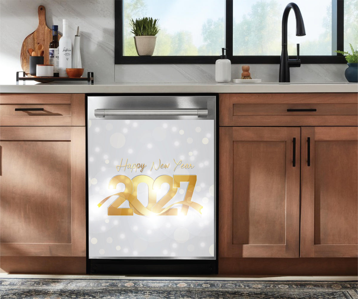 A stainless steel dishwasher in a modern kitchen setting, featuring a decorative 'Happy New Year 2027' dishwasher magnet on the door with a white bokeh background.